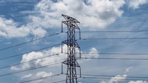 Electrical Transmission Tower with Power Lines Against Blue Sky and Clouds Stock Footage 339832308