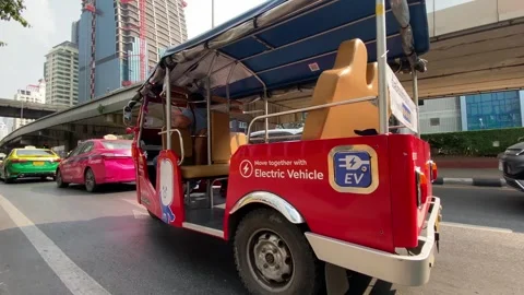 Electrical Tuk-Tuk navigate through a busy avenue in Bangkok, Thailand 4K Stock Footage 265857079