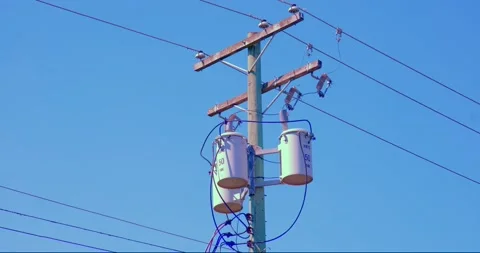 Electrical utility pole with transformers against clear blue sky Stock Footage 335720175