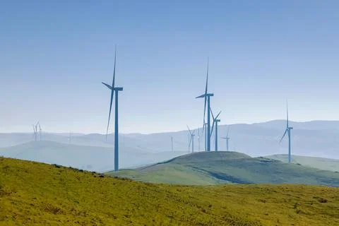 Electrical wind power mills over the blue sky. Stock Photos