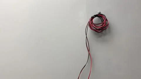 Electrical wire cable hanging from grey wall inside room. Interior decoration Stock Footage 249729901