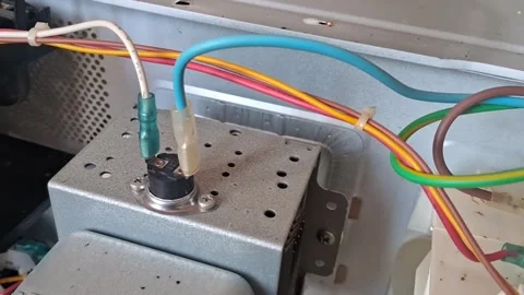 Electrical wire connections inside microwave appliance repair Stock Footage 346098304