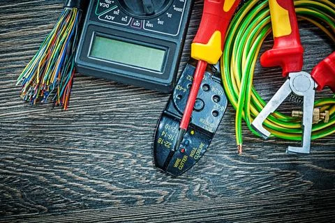 Electrical wire tester Screwdriver rolled Cable stripper on wooden board Stock Photos