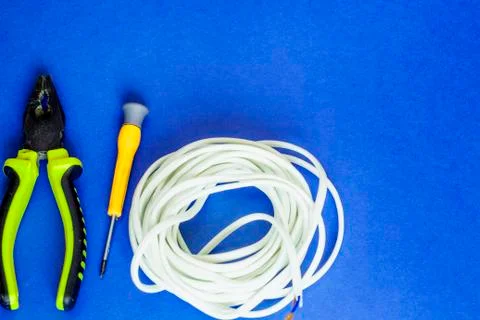 Electrical wires and tools lie on a blue table Stock Photos