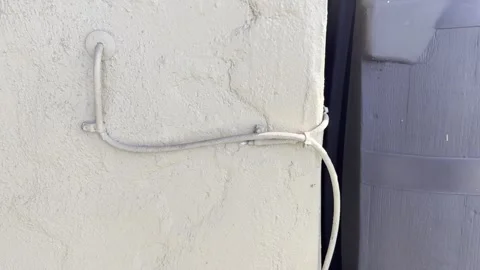Electrical Wires Painted Over on Yellow Stucco Wall Stock Footage 321142894