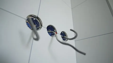 Electrical wires protrude from round holes in tiled wall Stock Footage 335644337