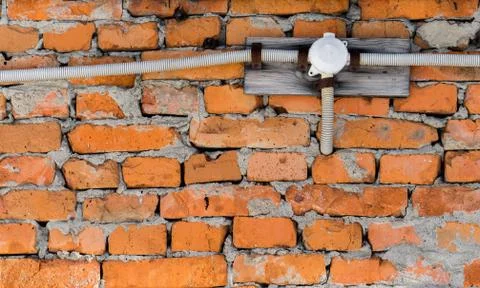 Electrical wiring on a brick wall Stock Photos