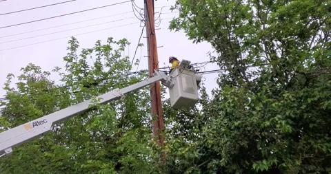 Electrical worker in a cherry-picker crane to work on a transformer. Waves Stock Footage 162759227