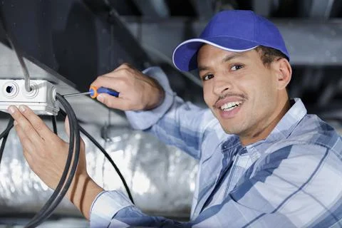 Electrical worker wiring in ceiling Stock Photos