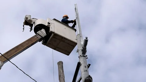 Electrical Workers On Telehandler With Bucket installing High tension wires Stock Footage 86403421