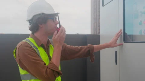 Electrical young man engineer examining maintenance cabinet system electric o Stock Footage 221196032