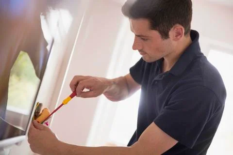 Electrician changing light fixture with tool Stock Photos