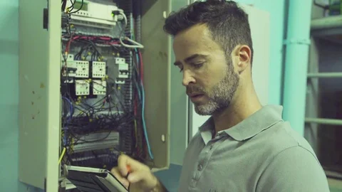 Electrician checking electric control cabinet Stock Footage 75168479