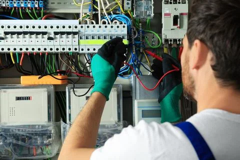 Electrician checking electric current with multimeter indoors, closeup Stock Photos