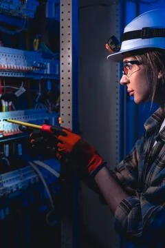 Electrician checking electrical switchboard with screwdriver. Engineering m.. Stockfoto's
