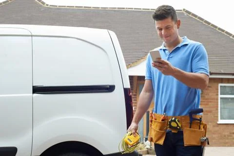 Electrician Checking Message On Mobile Phone Stock Photos
