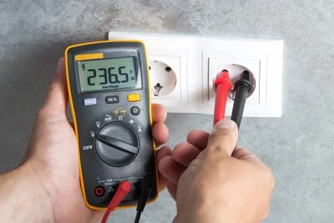 Electrician checking voltage in socket Foto stock