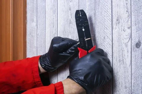 The electrician cleans the wire from the braid to connect the outlet Stock Photos