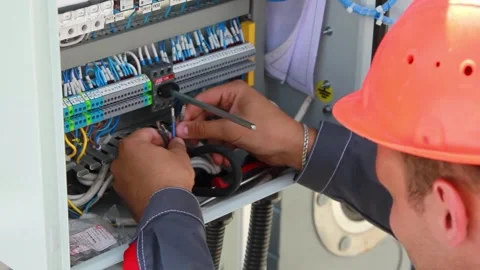 An electrician connects wires in an electrical panel 스톡 동영상 281948658