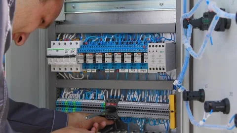 An electrician connects wires in an electrical panel Stock Footage 281948663