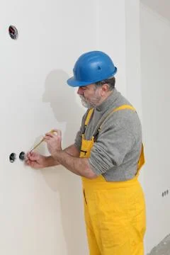 Electrician at construction site testing installation Stock Photos