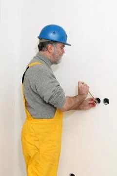 Electrician at construction site testing installation 写真素材