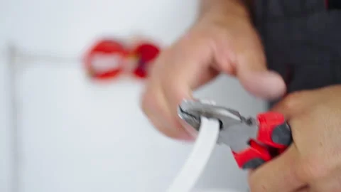 Electrician cutting electrical cable with pliers Stock Footage 344874492