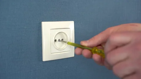 An electrician disassemble the socket on the wall with a special screwdriver Video stock 151999558