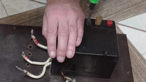 An electrician disassembles and repairs an old circuit breaker Stock Footage 334965544