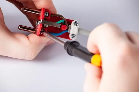 Electrician disassembles electric plug. Electric plug with outlet isolated on Stock Photos