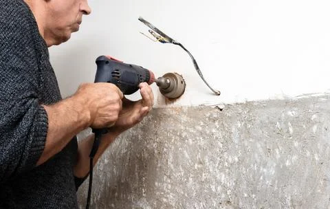 An electrician drills a wall, Installing a socket box into a wall, an elect.. Stock Photos