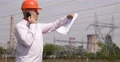 Electrician Engineer Man Talk Mobile Phone Power Plant Energy Station Plan Paper 4k or 4k+ Resolution