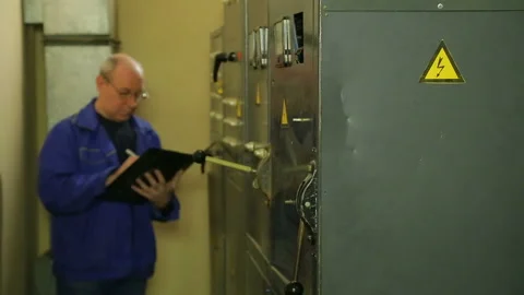 Electrician engineer records the readings of electrical appliances in the shield Stock Footage 104977757