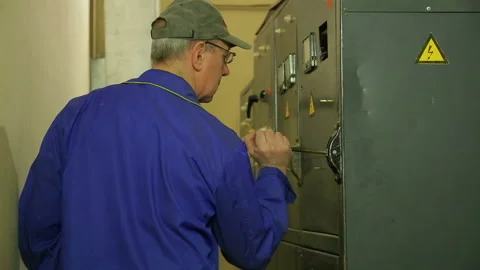 An electrician engineer turns on the electricity in the panel and records the Stock Footage 105122605