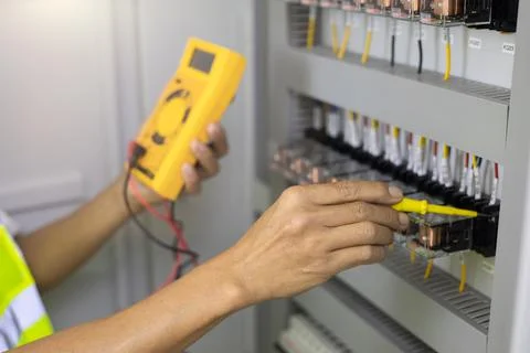 Electrician engineer work tester measuring voltage and current of power elect Stock Photos