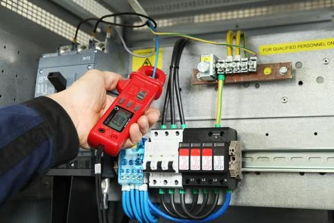 Electrician engineer work tester measuring voltage and current of power elect Stock Photos