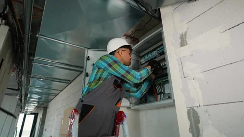 Electrician fixing electrical panel in new building construction Stock Footage 312836781