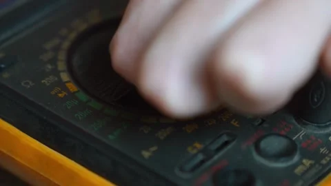 Electrician hand turning digital multimeter dial Stock Footage 327664220