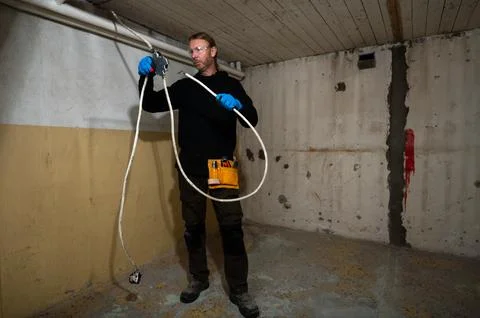 Electrician handling cables while working on electrical junction box Stock Photos