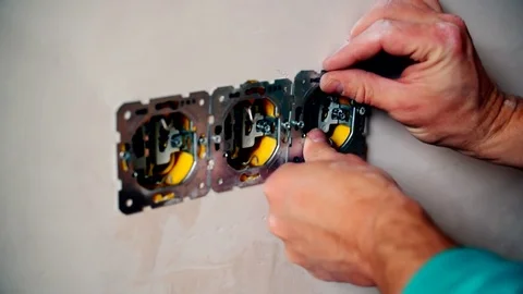Electrician hands install electrical wall sockets Stock Footage 71168105