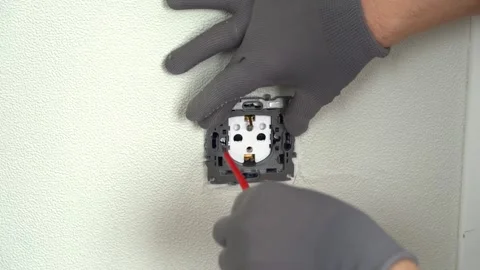 Electrician hands install socket using screwdriver. Replacing electrical outlet Stock Footage 282172487