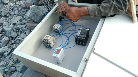 Electrician Hands Wiring Components Inside an Industrial Control Panel Box Stock Footage 340099867