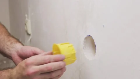 Electrician inserts a plastic plug into the hole in the wall 動画素材 147172722