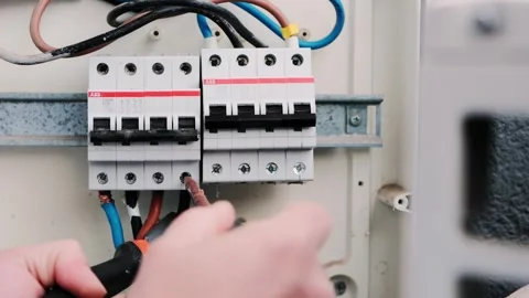 Electrician installing circuit breakers inside an electrical panel Stock Footage 327465501