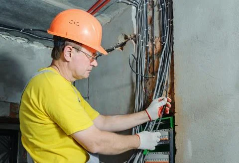 The electrician is installing electric wires. Stock Photos