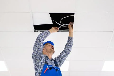 Electrician Installing LED Ceiling Light Stock Photos