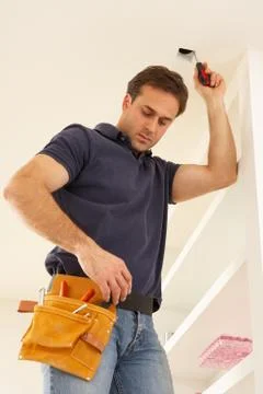 Electrician Installing Light Fitting In Home Stock Photos