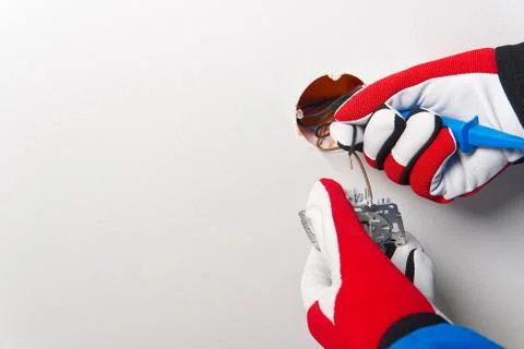 Electrician installing light switch on painted wall with screwdriver. Man ins Stock Photos