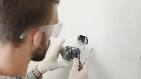 Electrician installing new current socket with screwdriver. Stock Footage 92317111
