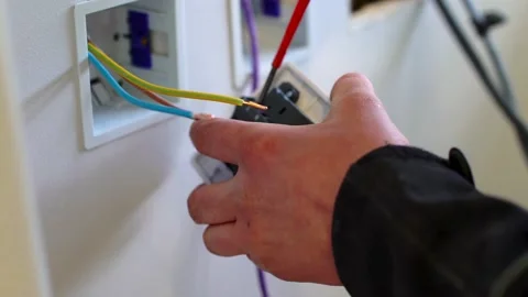 AN ELECTRICIAN INSTALLING A POWER PLUG SOCKET Stock Footage 169022350